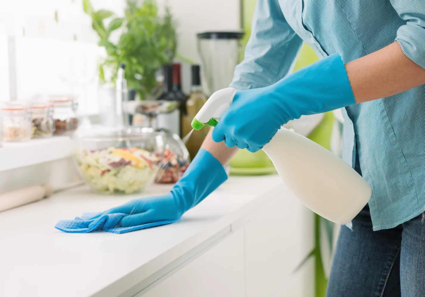 woman wipes down kitchen countertop
