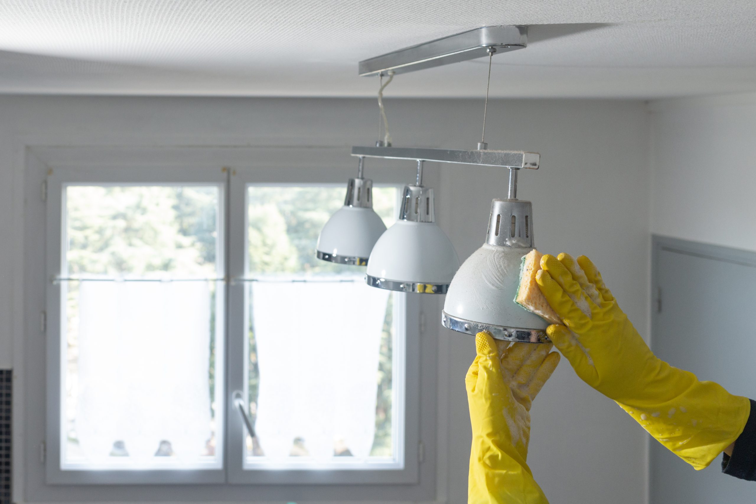 a cleaner wiping a lamp for end of tenancy cleaning kensington w8